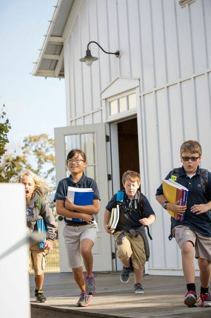 kids leaving schoolhouse with books